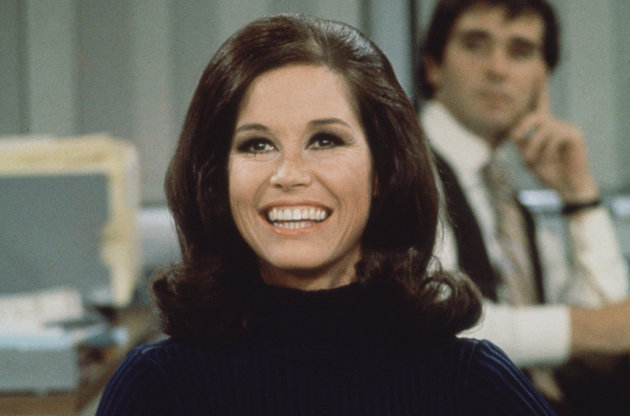 American actress and commediene Mary Tyler Moore (as Mary Richards) smiles broadly as she sits at a desk in a scene from 'The Mary Tyler Moore Show' (also known as 'Mary Tyler Moore'), Los Angeles, California, 1970. (Photo by CBS Photo Archive/Getty Images)
